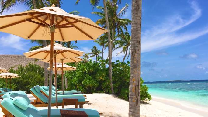 马尔代夫蓝天下的沙滩与泳池躺椅
