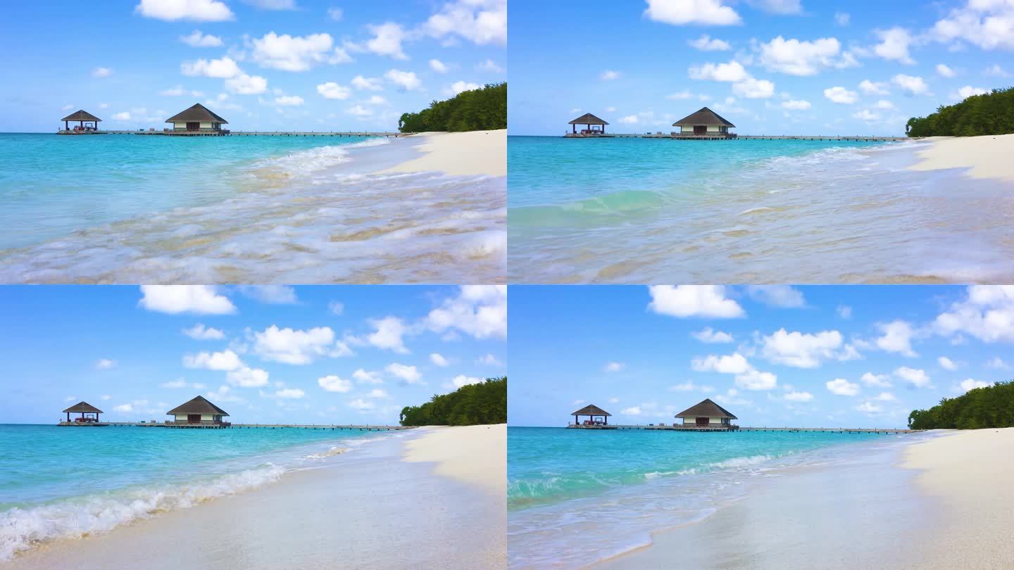 马尔代夫蓝天下的海浪、沙滩与水屋