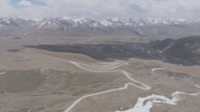 航拍西藏拉萨琼穆岗嘎雪山下的盘山公路