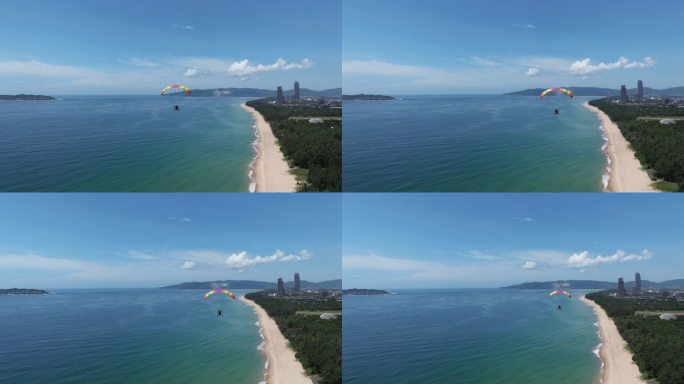 蓝天白云下动力伞沿着三亚海棠湾海岸线飞行