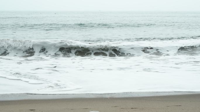 海浪不断翻涌上沙滩，激起阵阵浪花