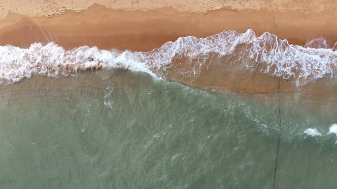 航拍威海国际海水浴场秋季的沙滩海浪