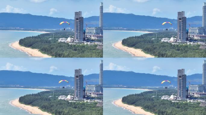 蓝天白云下动力伞沿着三亚海棠湾海岸线飞行