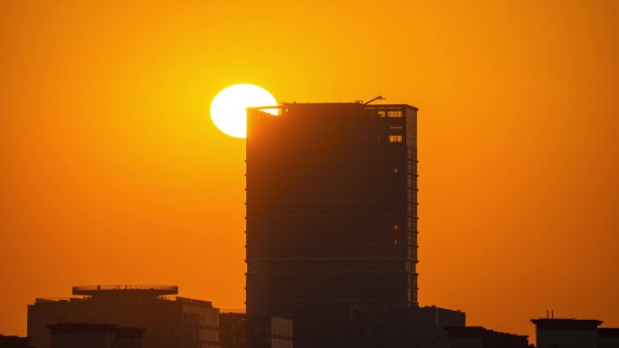 日落太阳穿过城市建筑一角