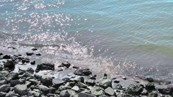 波光粼粼的海面，浪花冲打着岸边的礁石