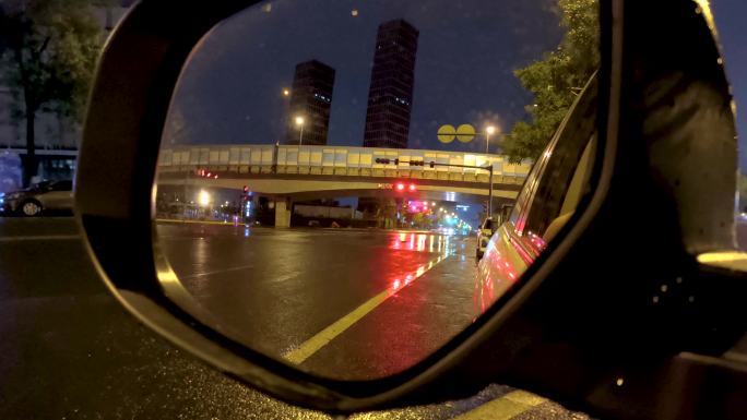 雨中夜晚，透过后视镜的公路