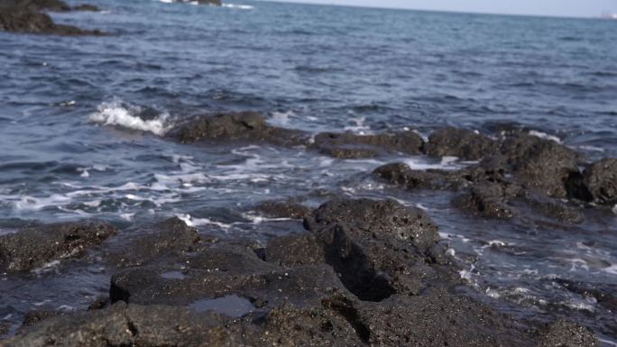 济州岛海边黑礁石海浪