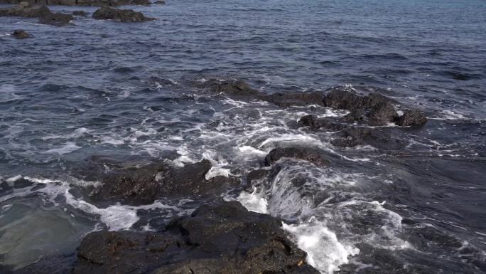 济州岛海边黑礁石海浪