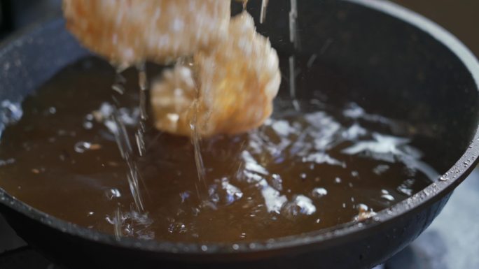 一位厨师在用油锅制作炸腐竹