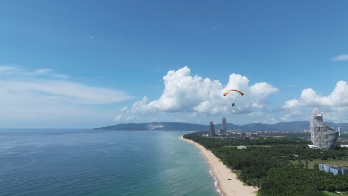 航拍三亚海棠湾蓝天白云动力伞沿海岸线飞行