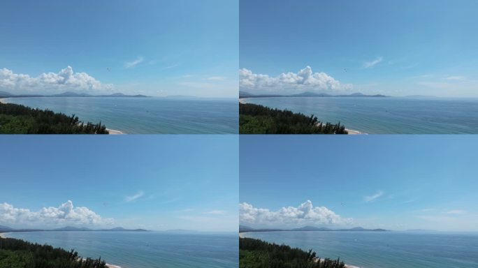 航拍蓝天白云下三亚海棠湾动力伞飞行及沙滩