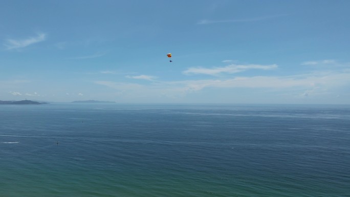 航拍三亚海棠湾蓝天白云动力伞沿海岸线飞行