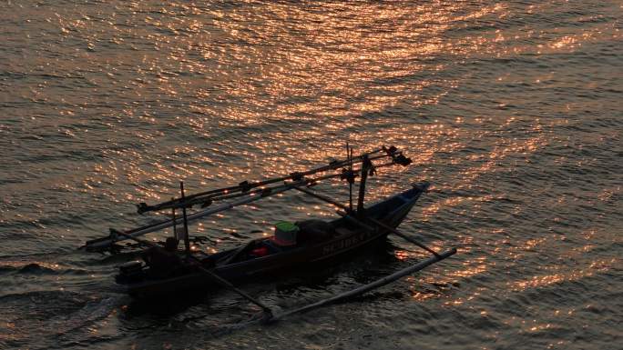 夕阳下的渔船驶向大海