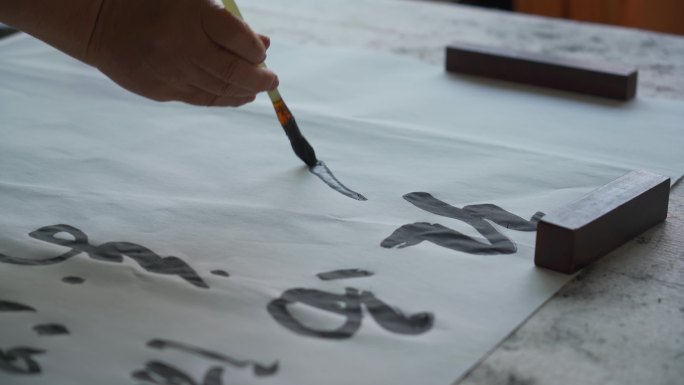 一位著名的中国书法家在用毛笔书写作品