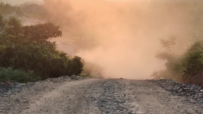 夕阳灰尘基建工地工程货车爬坡山路灰尘滚滚