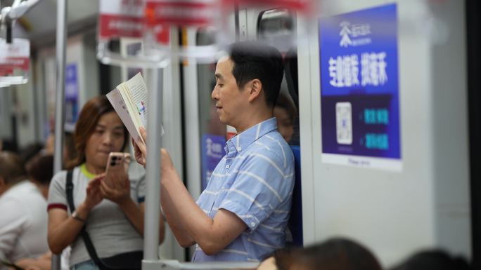 地铁上看书的人 中年人看书地铁学习