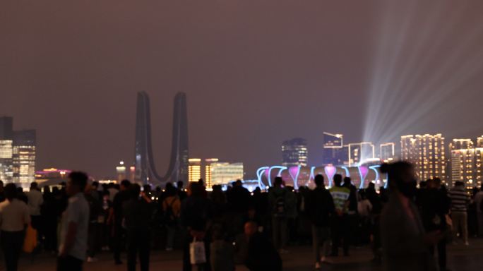 人们在城市阳台观看亚运会开幕式灯光秀