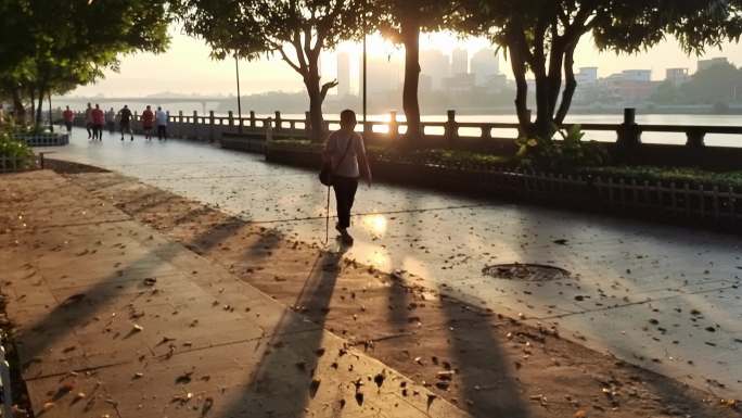 早晨逆光阳光晨跑进江休闲晨行路走路散步