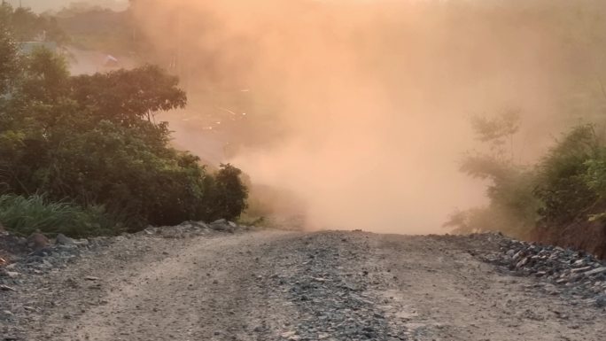 逆光烟雾缭绕滚滚夕阳黄昏山路灰尘烟雾弥漫