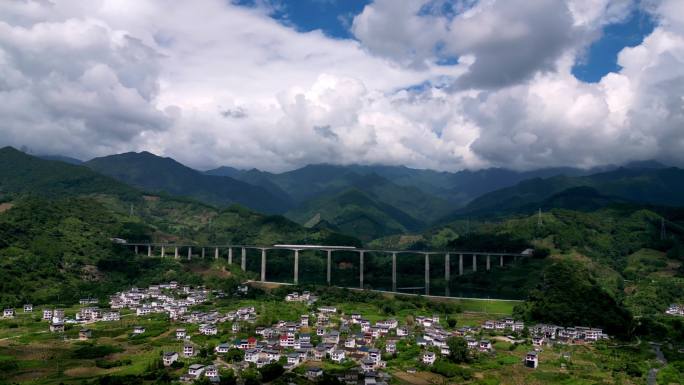 高铁动车列车高铁经过蓝天白云下的山谷乡村