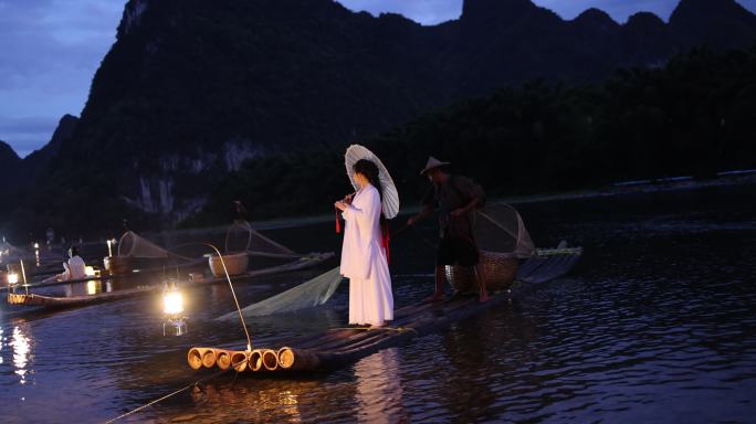 桂林漓江竹筏上的美女与渔夫洒下渔网