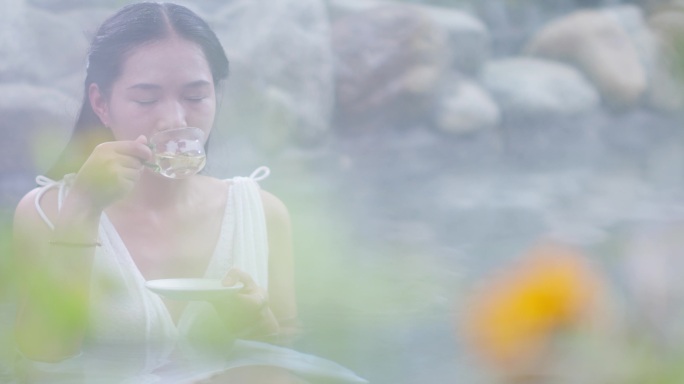 女子泡温泉惬意享受品茶