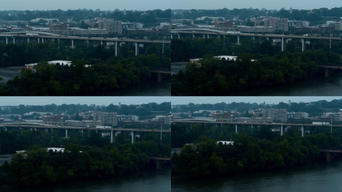 詹姆斯河大桥上夜晚烟雾弥漫的城市景观:远处的弗吉尼亚州里士满市中心。航拍镜头与下降摄影机运动
