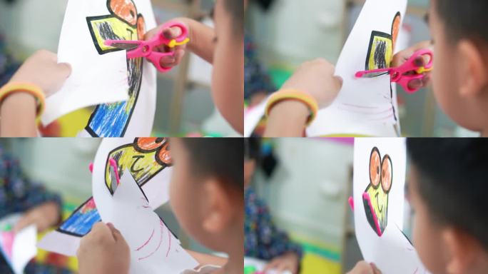 小男孩练习剪刀彩色剪纸卡通形象。