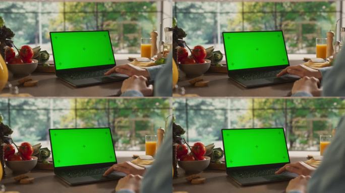 匿名妇女在她的厨房使用笔记本电脑模拟绿屏Chromakey显示与运动跟踪占位符。女性参加在线烹饪课程
