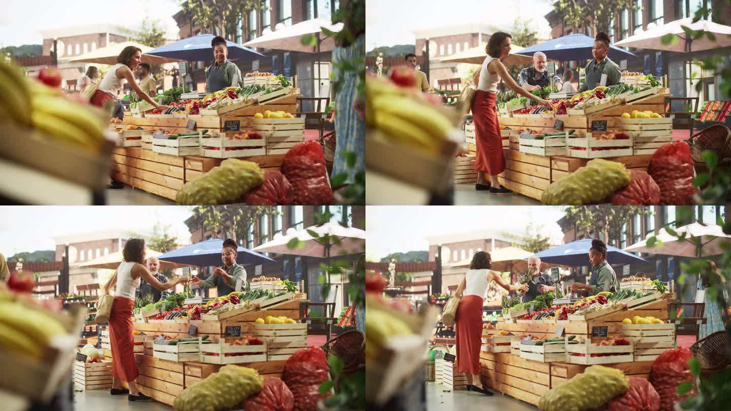西班牙女顾客向一对多民族农民夫妇购买两个蒜头和一个菠萝。成功的成年人在城市广场市场管理小型商业农场摊