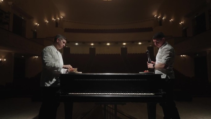两位厨师在歌剧院的艺术表演，厨师在舞台上用大钢琴做饭