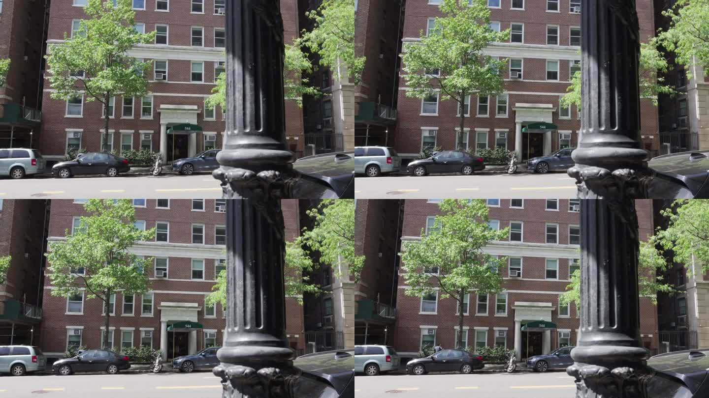 一辆汽车和一辆摩托车停在纽约曼哈顿一栋老红砖公寓大楼前