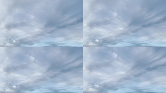 浅灰色的乌云在天空中滑落。一层云在蓝色的天空中水平移动在相反的方向。时间流逝。