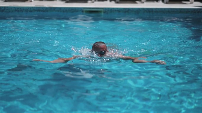 体育运动中男子游泳运动员蛙泳的一种泳姿。泳池，前视图，游泳技巧，慢动作