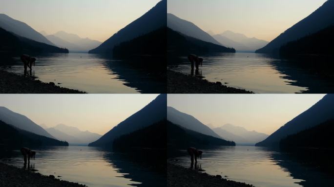 年轻女子在清晨的山间湖中游泳