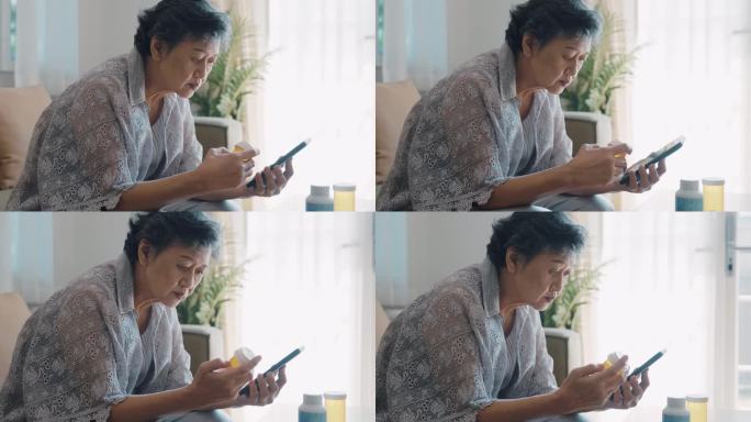 亚洲老年妇女在家一边用智能手机一边看药瓶上的标签。