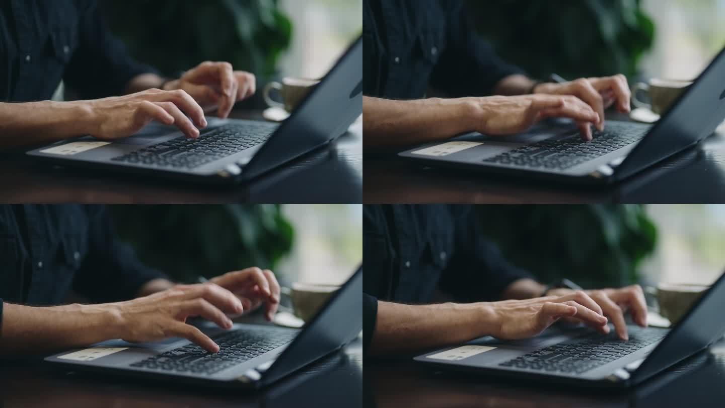 男性IT专业人员的手在笔记本电脑的键盘上，特写，从咖啡馆远程工作的人