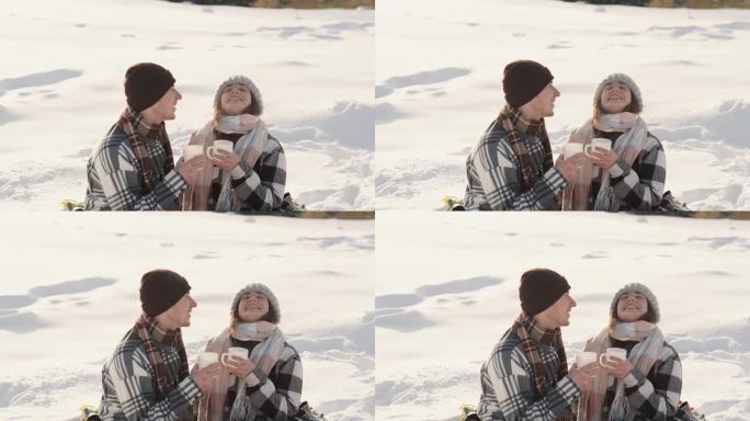 这段视频充满了一对夫妇在雪地上度过寒假的温暖和快乐。一个年轻的家庭，一个男人和他的妻子在咖啡和茶的温