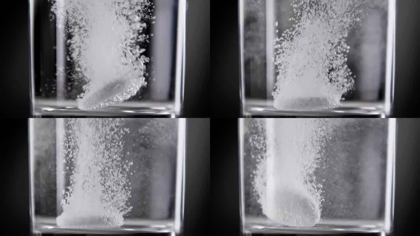 泡腾片落入玻璃杯中的淡水(特写)。在演播室拍摄的宏观上制作运动生活方式的健康饮料。服用止疼药丸和悬浮