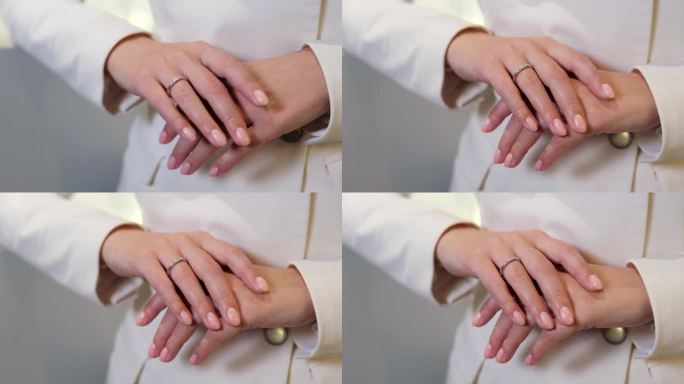 在珠宝店里，戴着昂贵而美丽的金钻戒的女孩把手放在另一只手上。准新娘的订婚戒指。在珠宝店挑选结婚戒指。