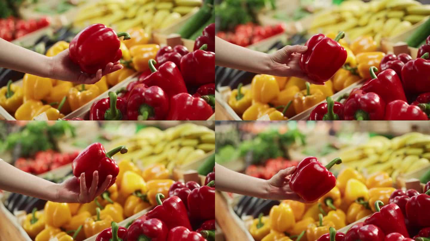 一名妇女在当地农贸市场的摊位上购买新鲜蔬菜。特写镜头聚焦于一个女人的手从一个天然农产品的摊位上选择一