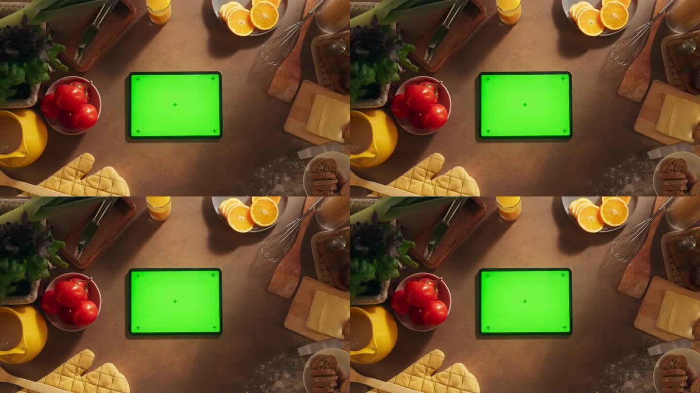 一个平板电脑与模拟绿色屏幕显示的自上而下的视图。一个设备水平躺在木制厨房桌子上的静态镜头。在线教程和