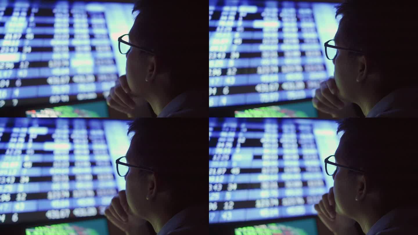 一个商人晚上在电脑前分析数据，情绪紧张。后视镜拍摄。