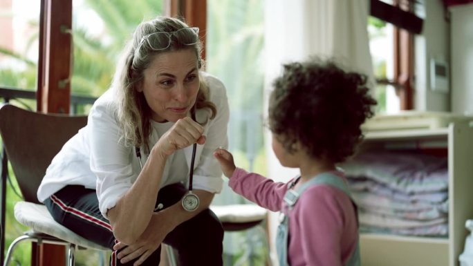 医生与孩子在医院进行健康咨询时击掌和碰拳。儿科医生，手和医疗专业人员与孩子一起使用快乐的表情符号，手
