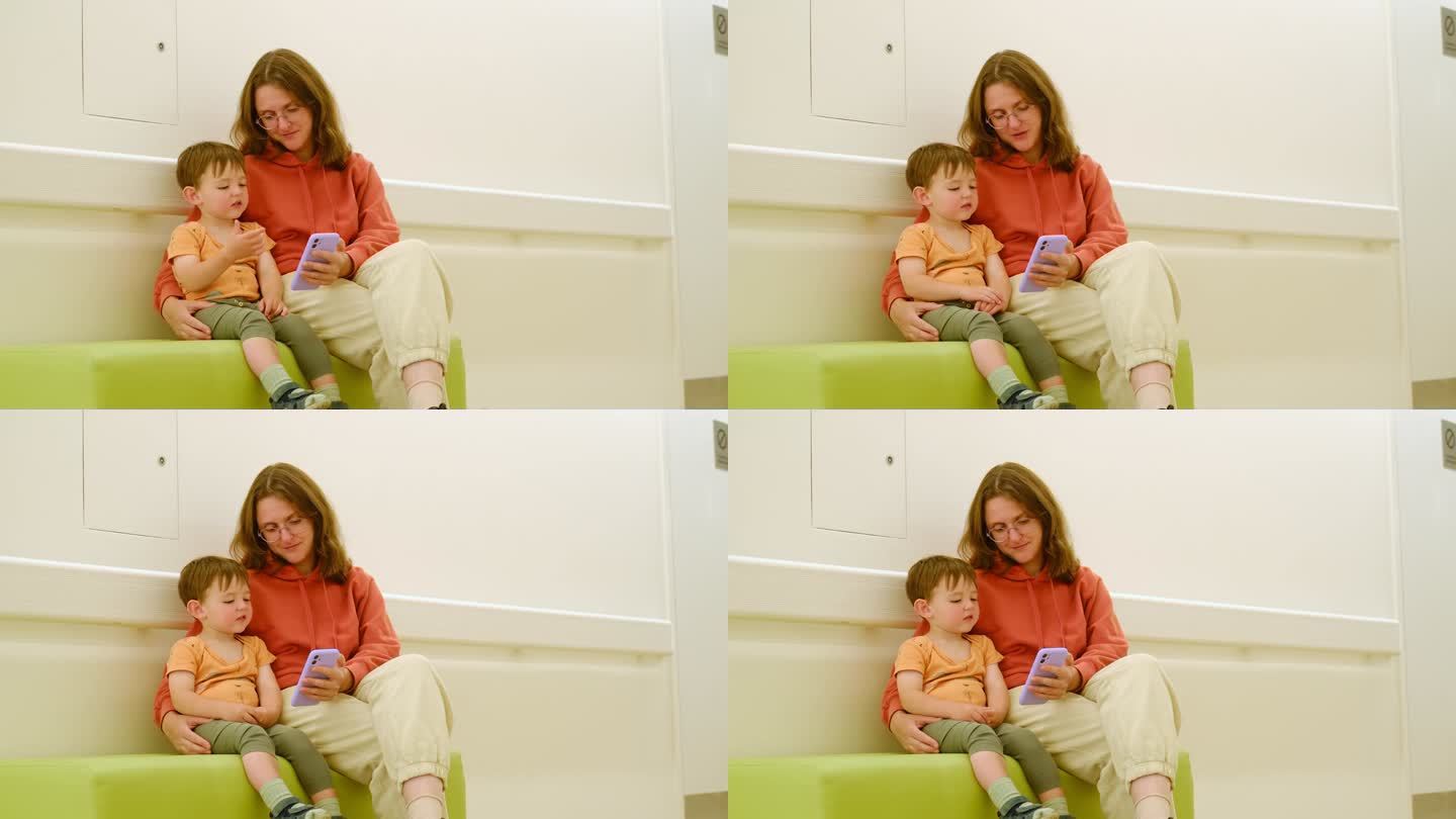 母亲和她的孩子在医院的候诊室里，等待医生的来访。两岁男童(2岁)