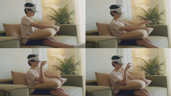一个亚洲男孩正坐在客厅的沙发上尝试虚拟现实眼镜。