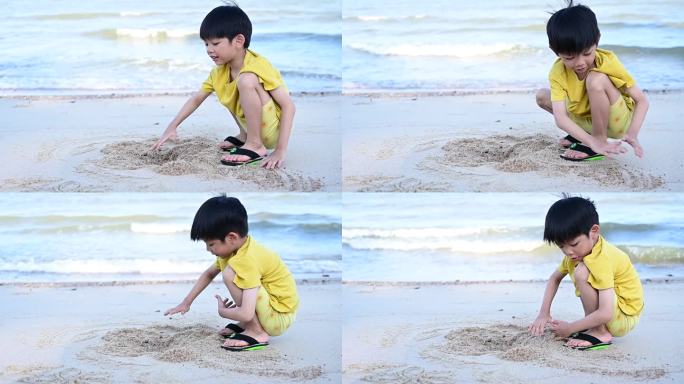 亚洲可爱的男孩正在沙滩上玩沙子和写字，慢动作的场景