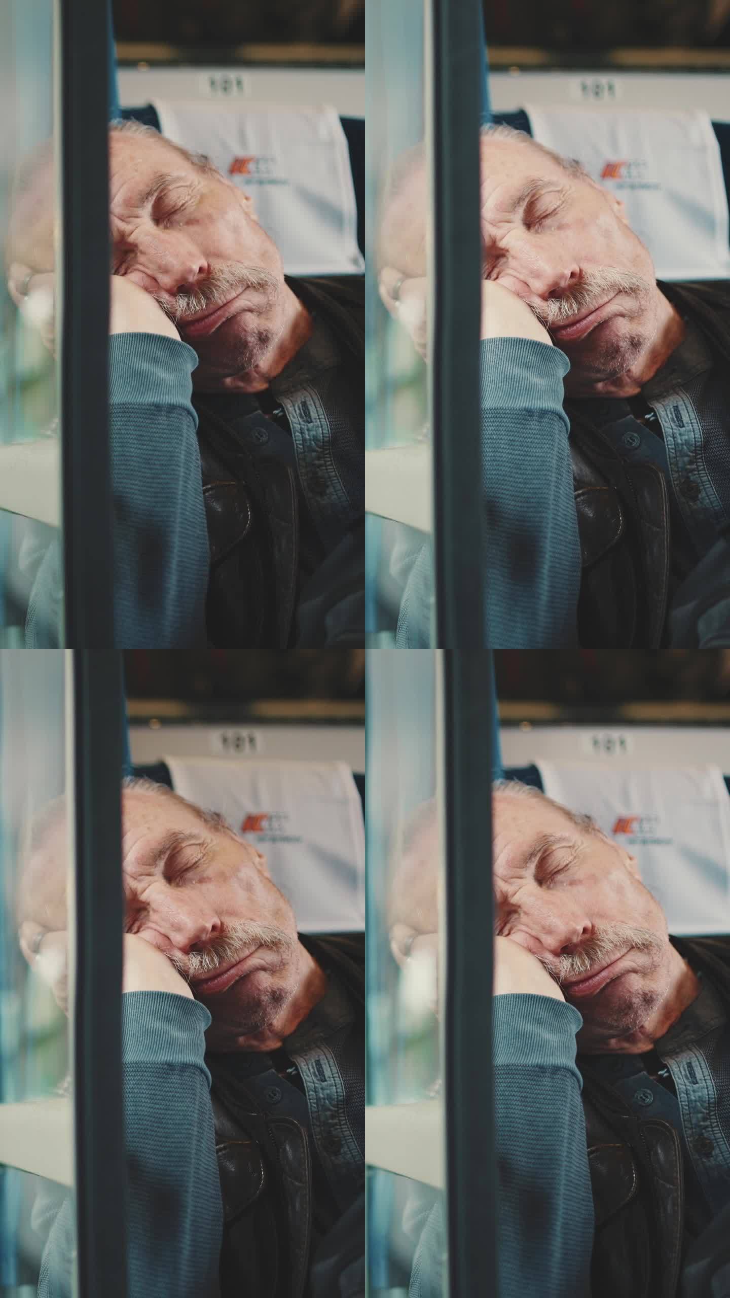 垂直视频，老人在火车上睡觉，通过双层玻璃观看