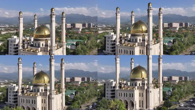 夏日，哈萨克斯坦阿拉木图市一座美丽的清真寺，金色的圆顶映衬着群山