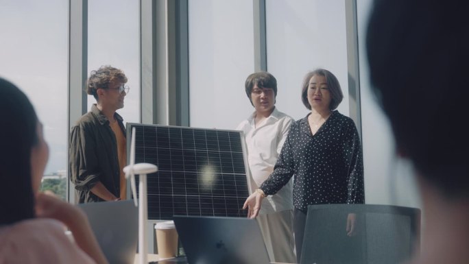 商务团队在会议室商务会议期间向同事展示太阳能电池板。
